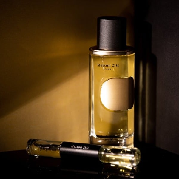 A Maison 21G Paris Eau de Parfum created for Hennessy, with a vial, in warm low light.