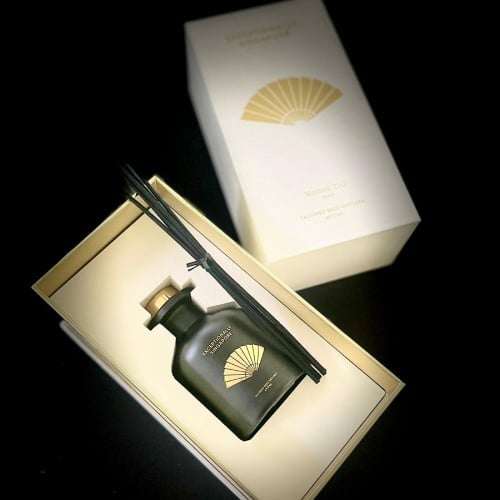 A Mandarin Oriental reed diffuser in its open gift box, the fan emblem in gold.