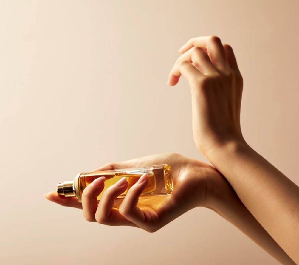 Applying a bespoke Eau de Parfum, created at Maison 21G Paris