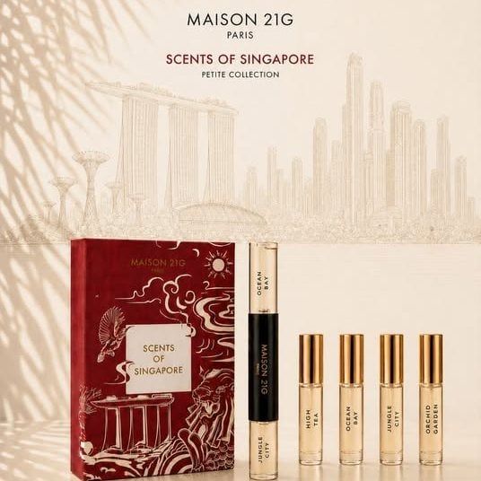 A travel coffret with its perfume sprays, before a drawn city skyline.